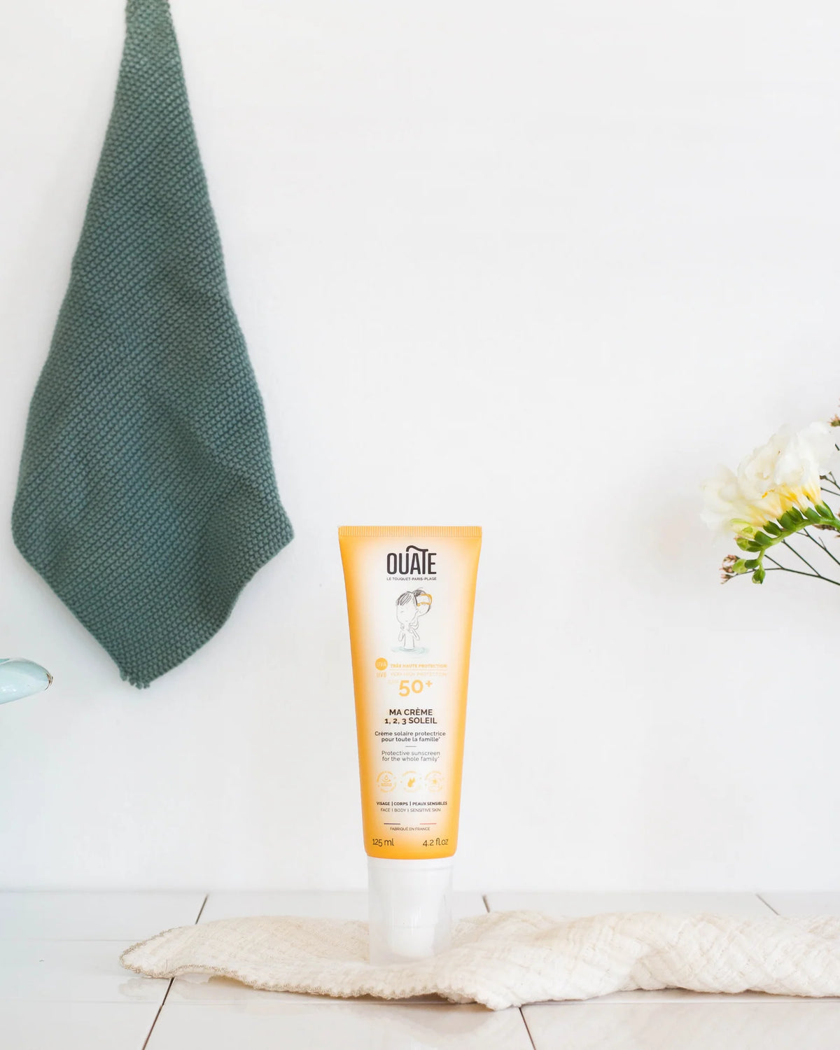 Ma Crème 1,2,3 Soleil Ouate, crème solaire SPF 50+ pour enfants et famille, tube jaune dans une salle de bain